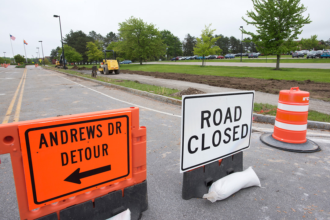 White "Road Closed" sign and orange "Andrews Dr Detour" sign.