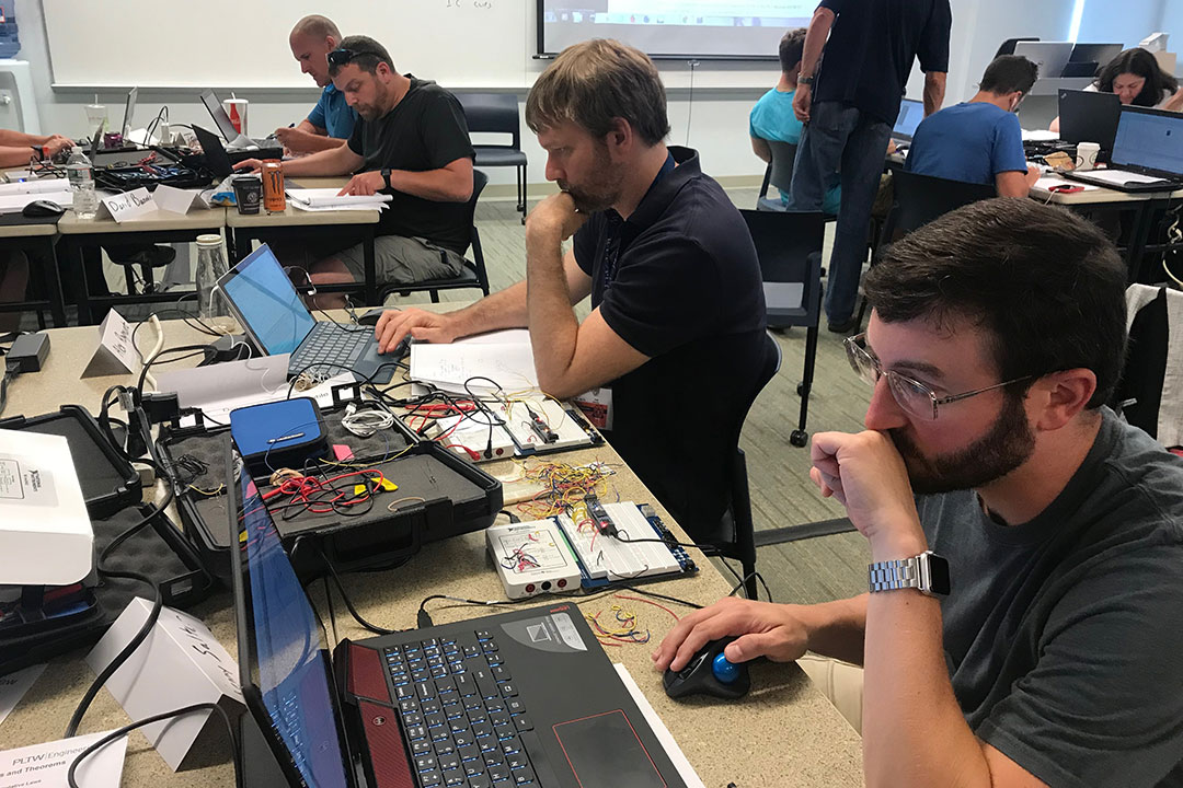 Workshop participants work on laptops.