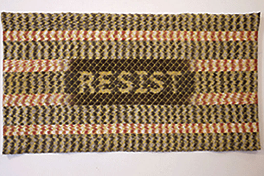 Knit rug with the word "RESIST" in the center.