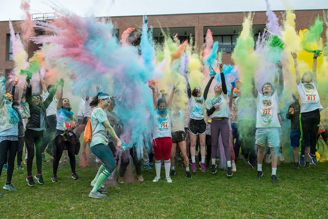 Student throw colored powder up into the air.