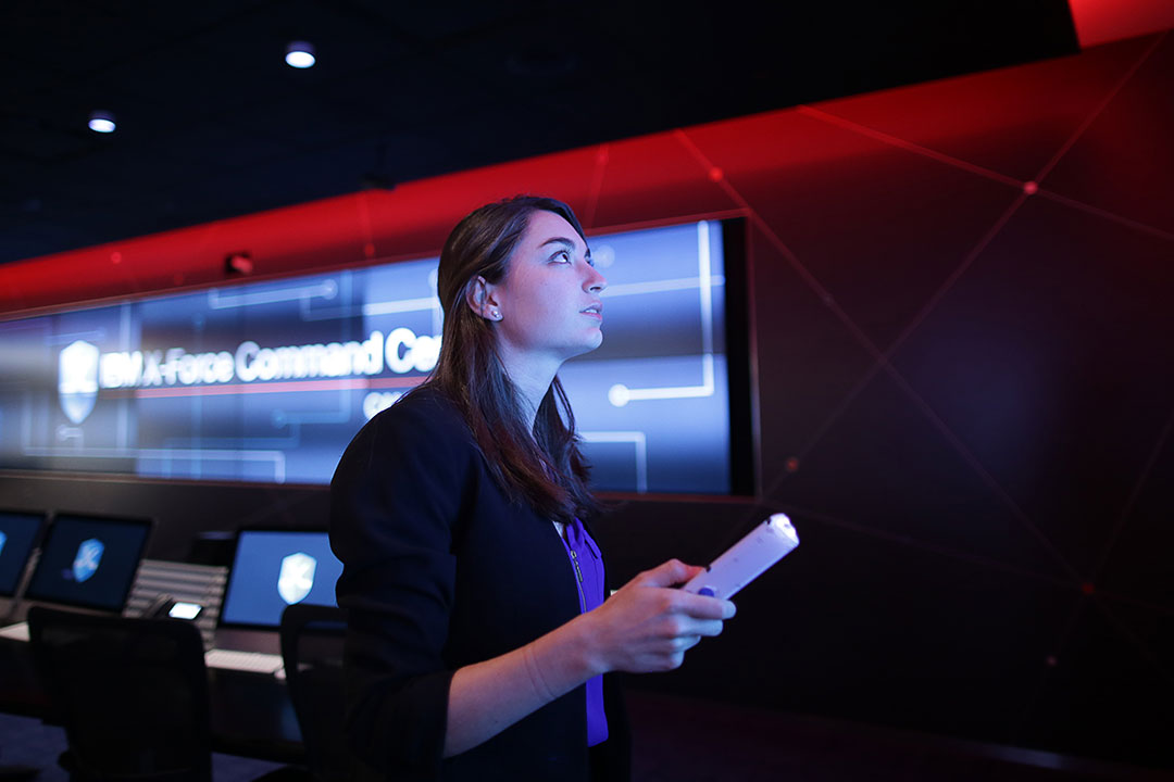 Woman looks at screen holding remote.