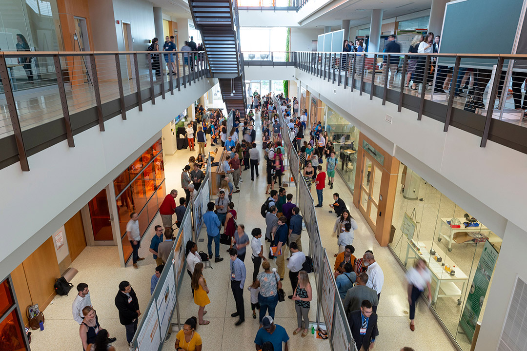 Overhead view of crowd of people in building lobby.