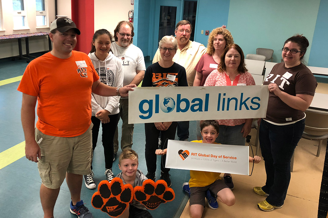 Group of people stands holding banner that reads "global links."