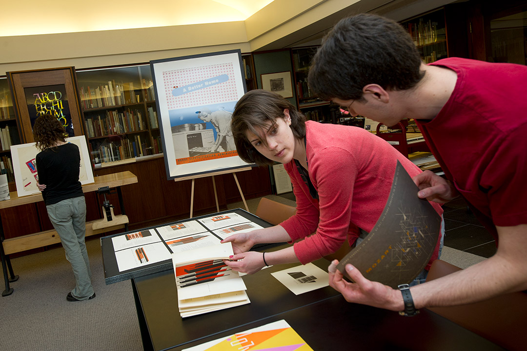 Students look at materials in library.