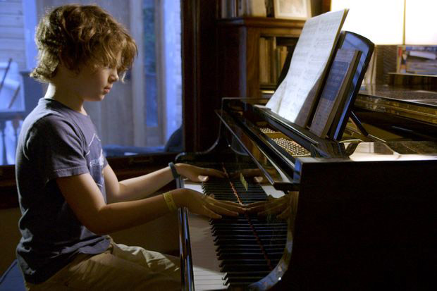 Boy plays piano.