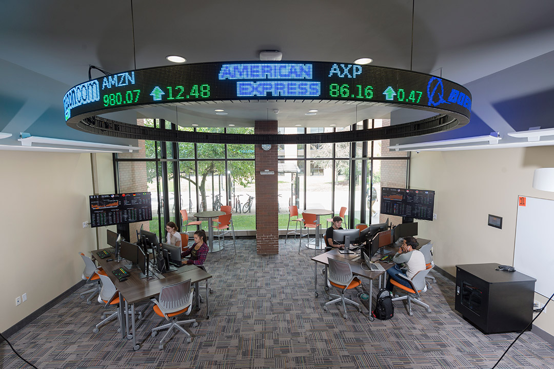 open lab with two computer workstations and digital stock ticker.