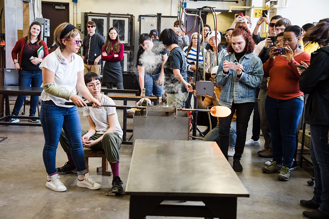 Aya Oki leads a demo for a crowd of people in RIT's hot shop. 