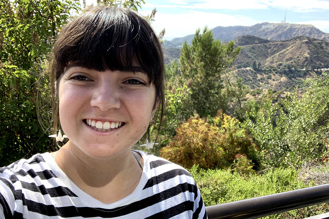 Cassie Valente takes a selfie with wilderness in the backdrop.