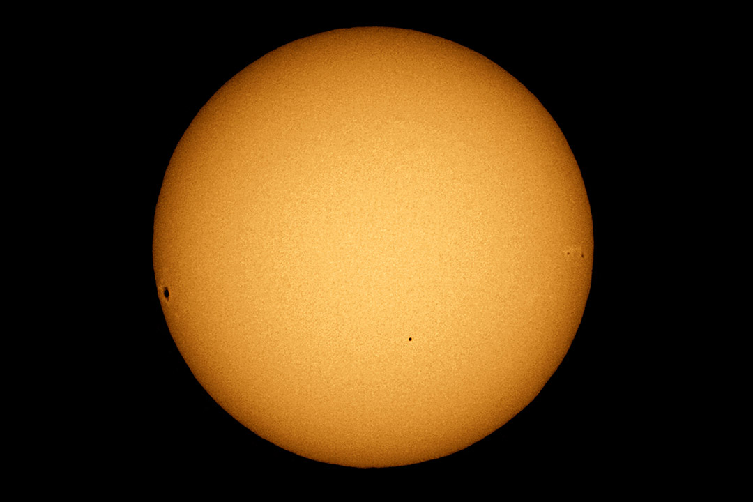 The sun with four small black dots.