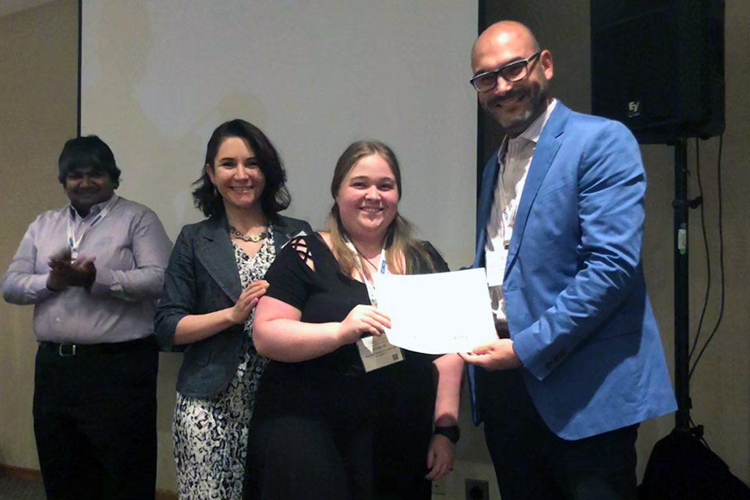 Student receives award while standing with professor.