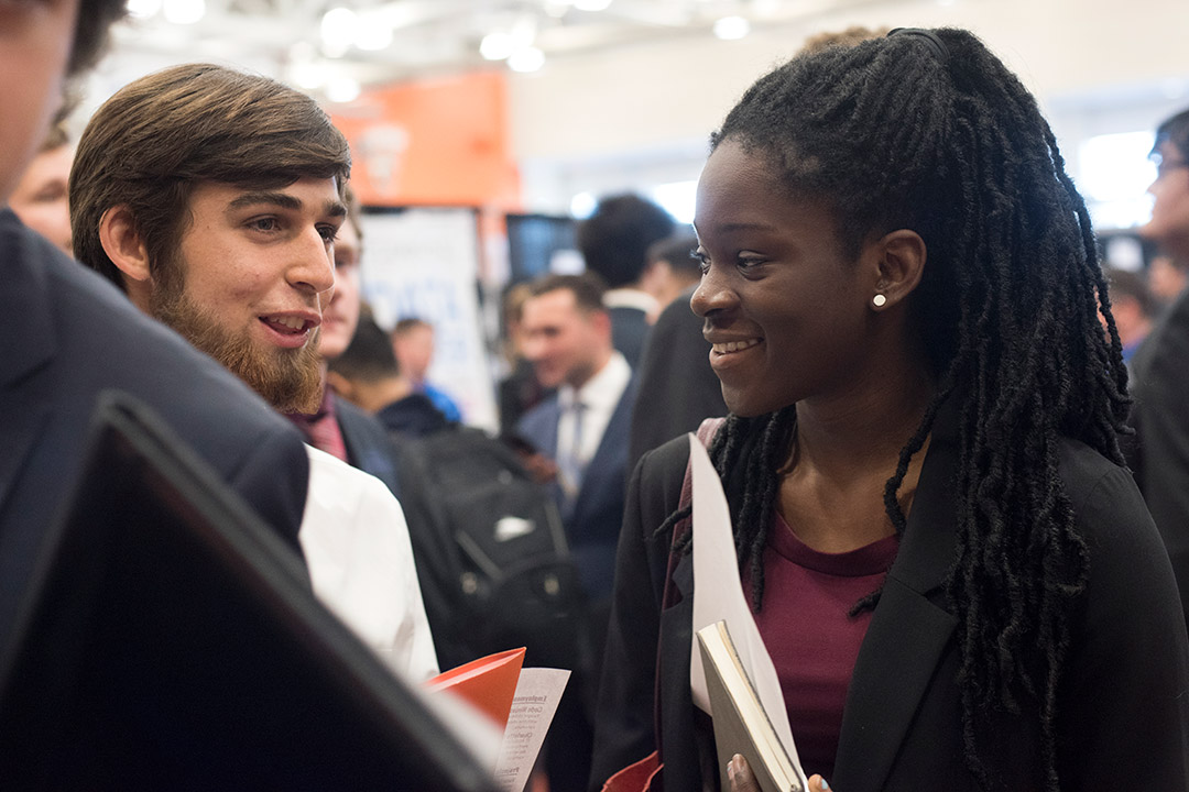 Two students talk at career fair.