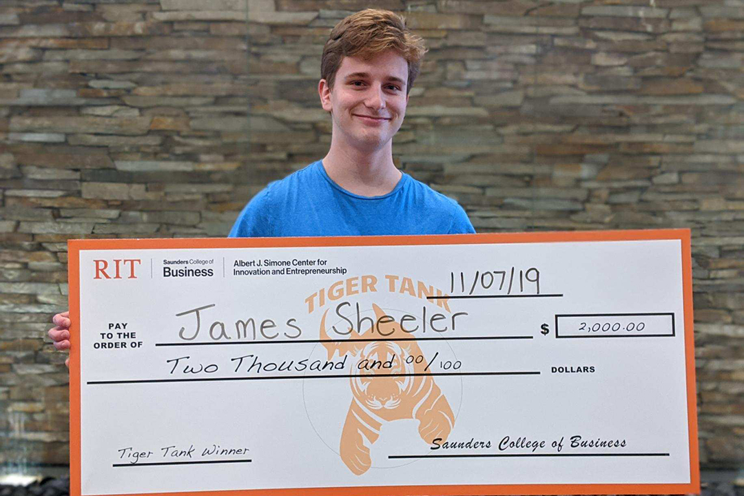 James Sheeler holds the giant $2,000 check he was awarded for winning the Tiger Tank competition.