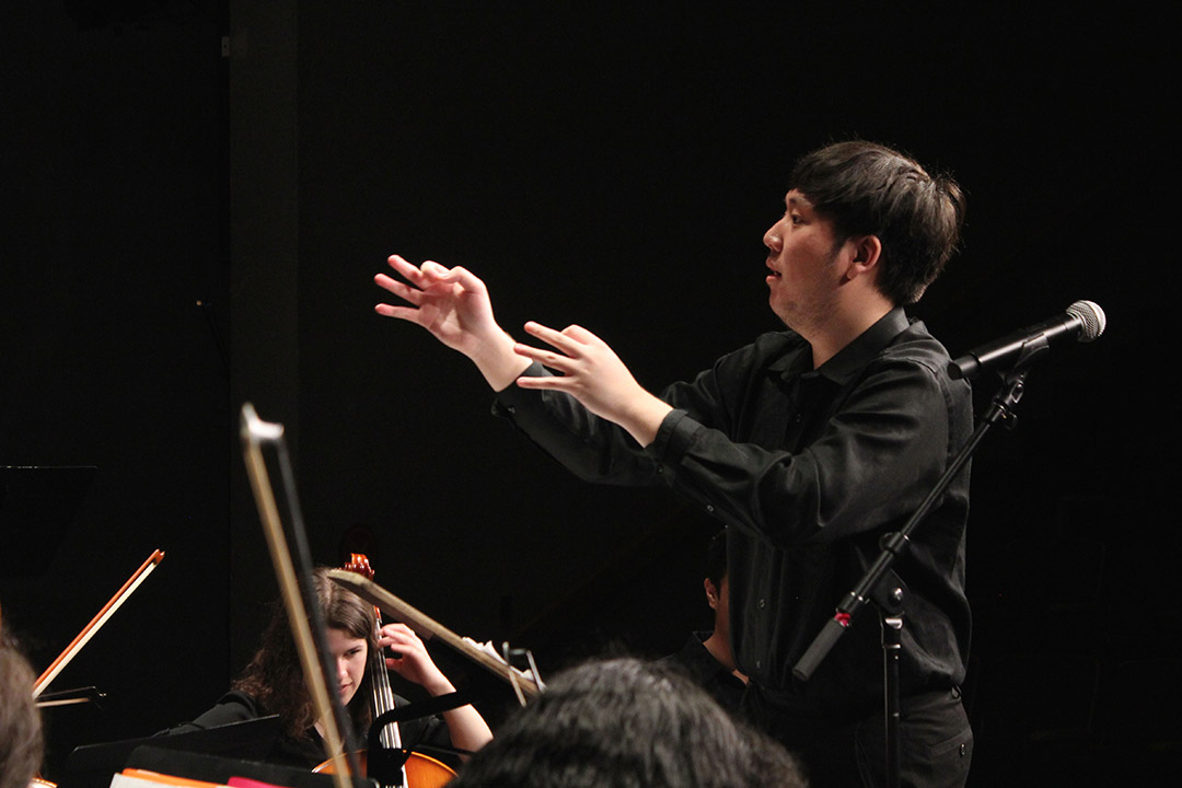 student conducting orchestra.