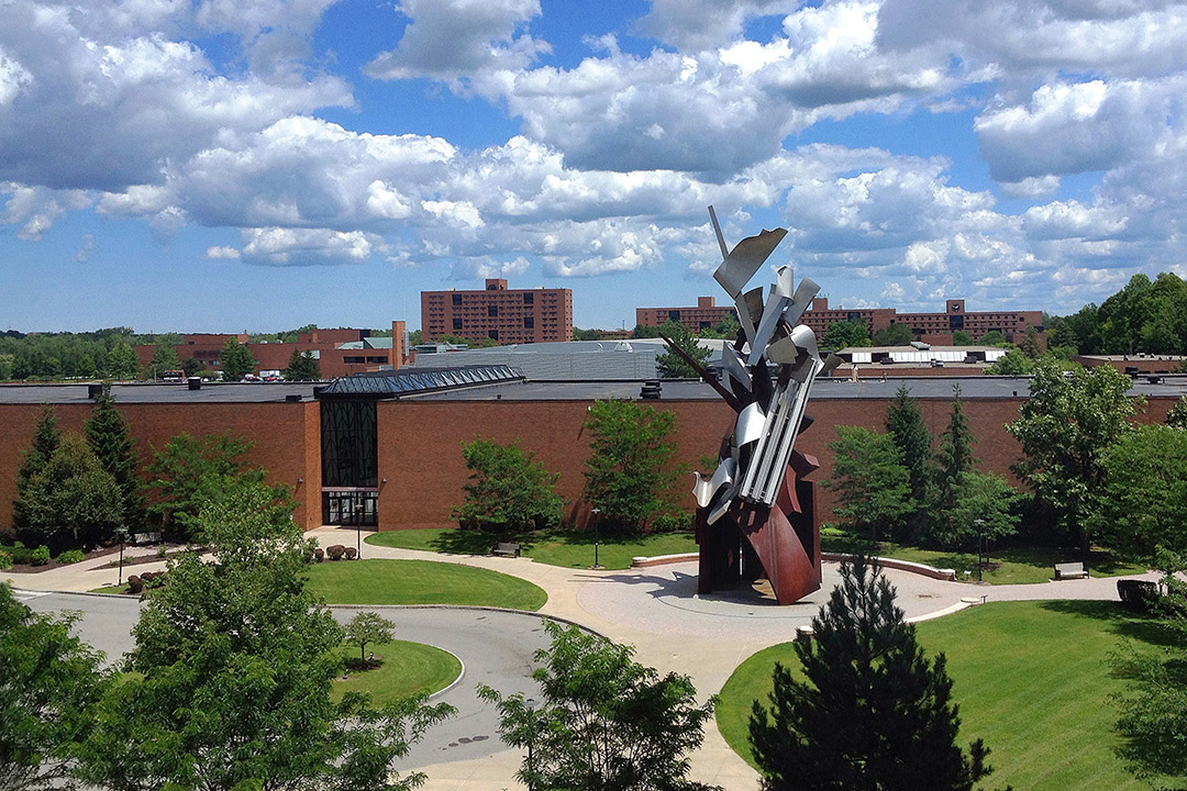 outdoor metal sculpture near brick buildings.