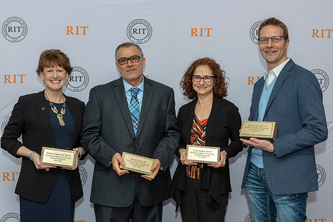 four people holding Golden Brick awards.