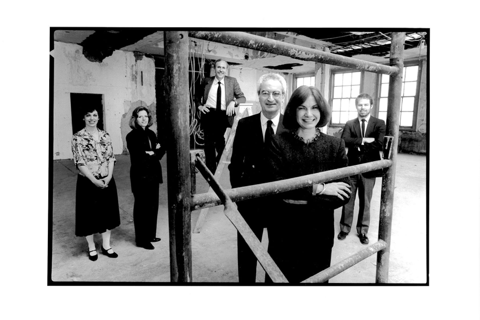 A black-and-white photo of Massimo and Lella Vignelli with co-workers at their new offices.