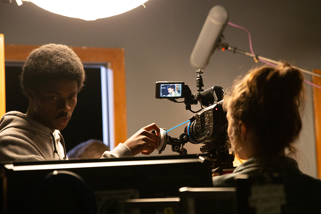 School of Film and Animation students adjust a camera during a video shoot in one of RIT's soundstages.