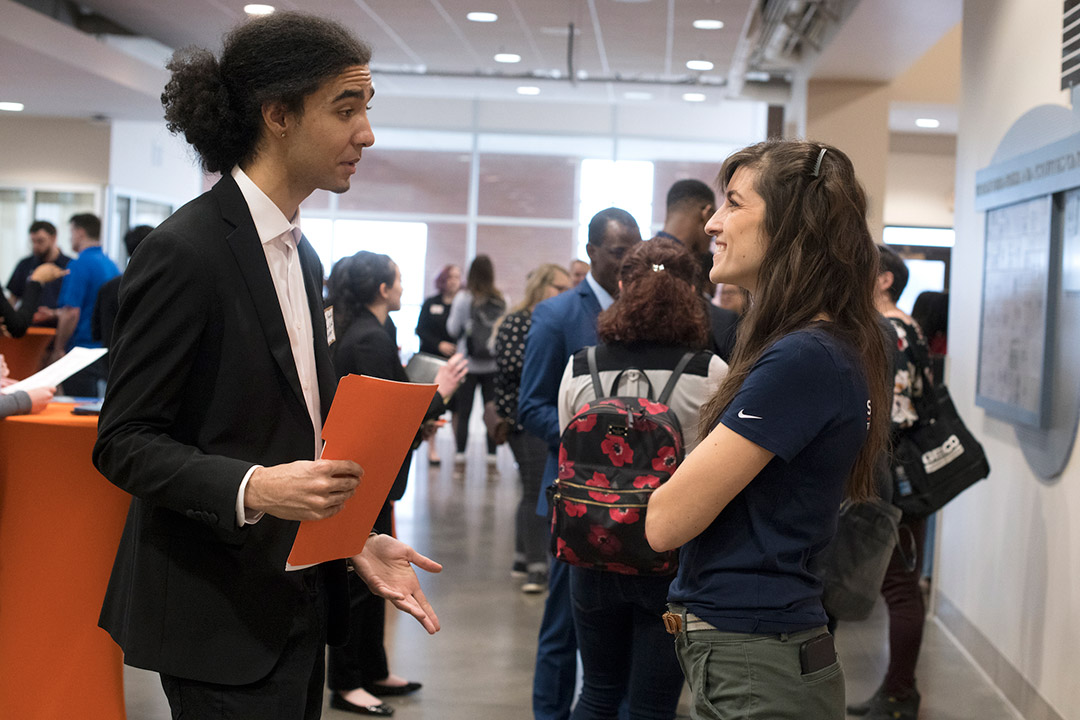 student and employer talking at career fair.