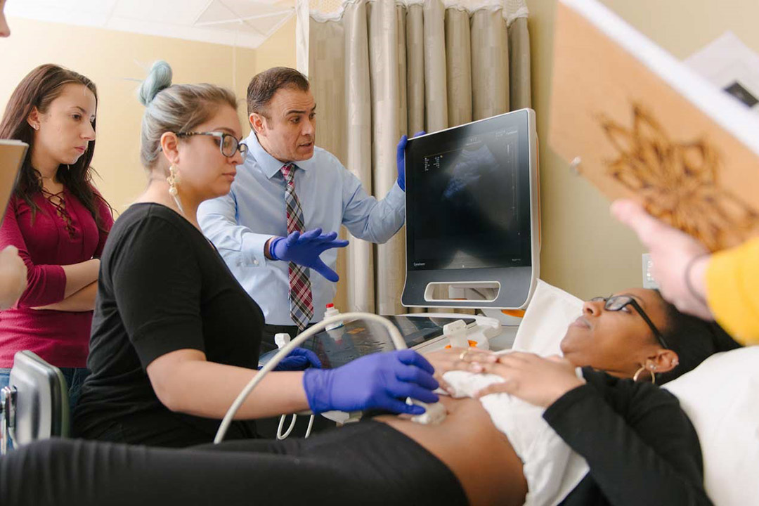 student practices ultrasound techniques on another student.