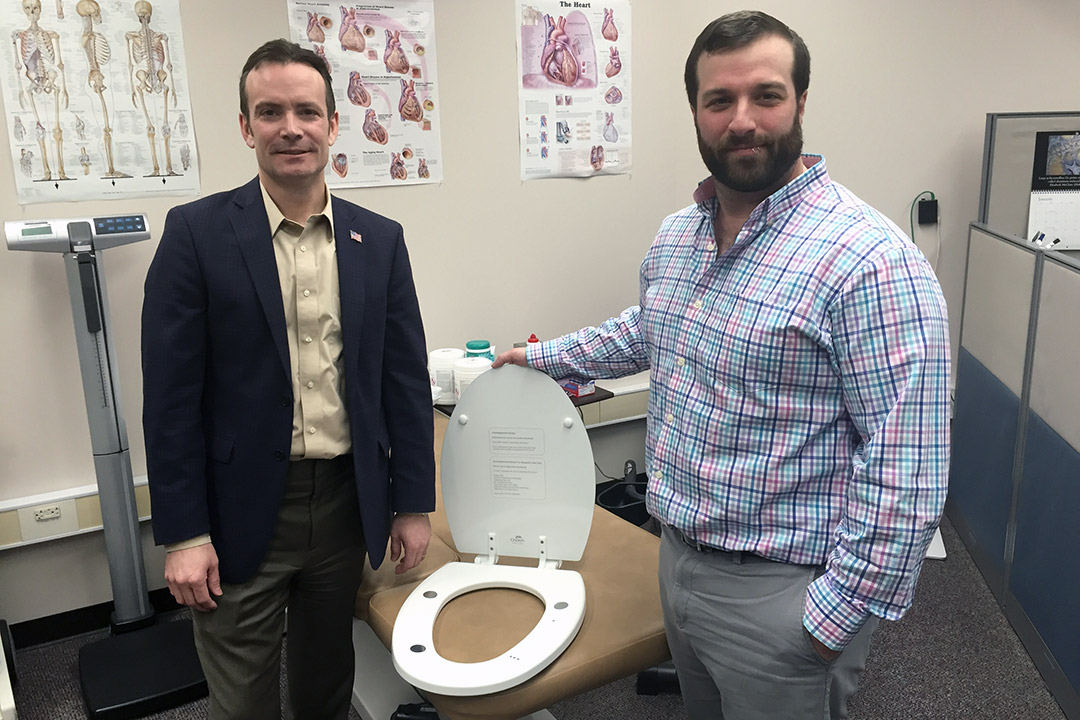 researcher and professor with toilet seat embedded with sensors.