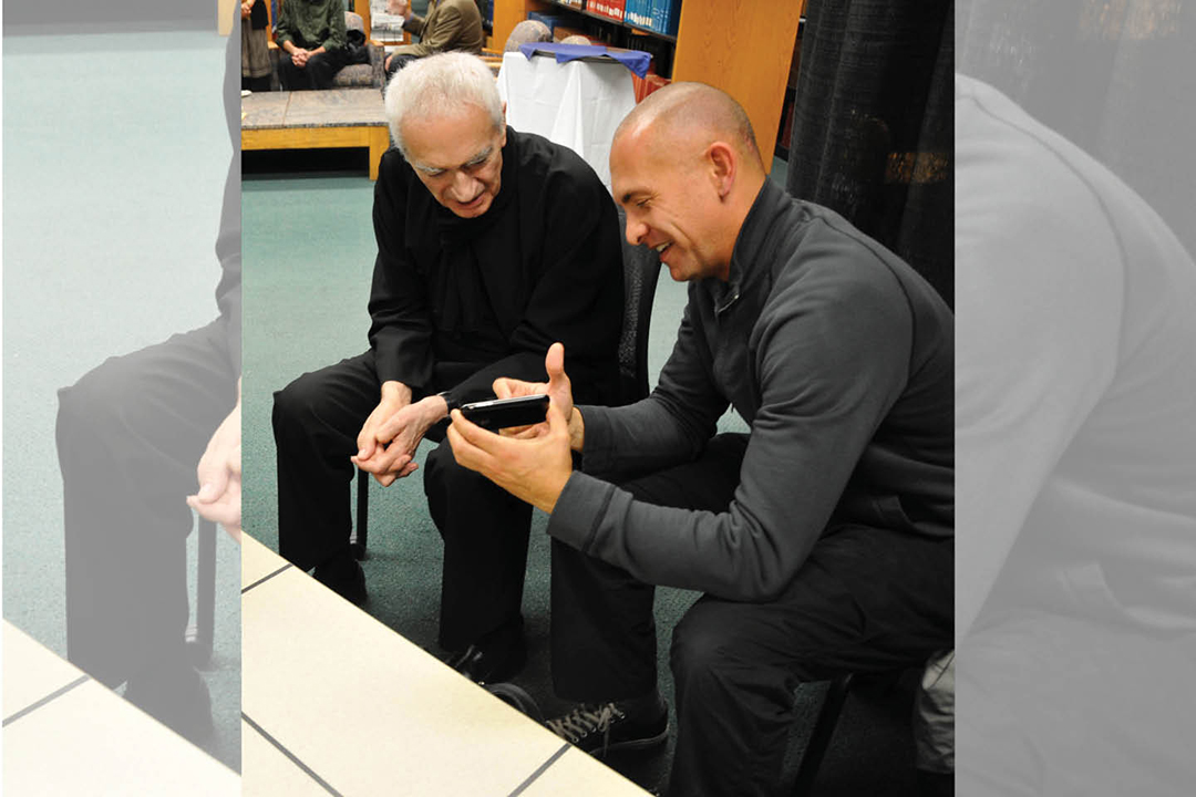 Josh Owen and Massimo Vignelli look at a student's design.