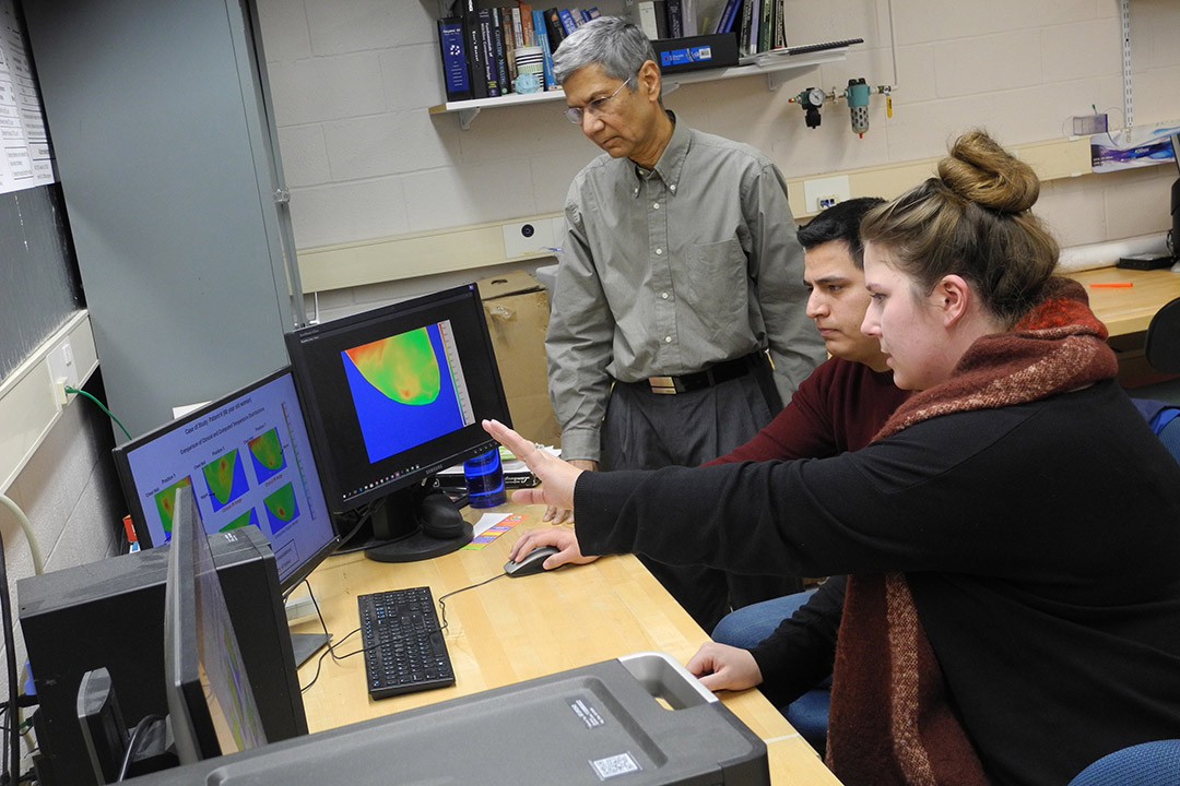 researchers looking at infrared images on computer screens.