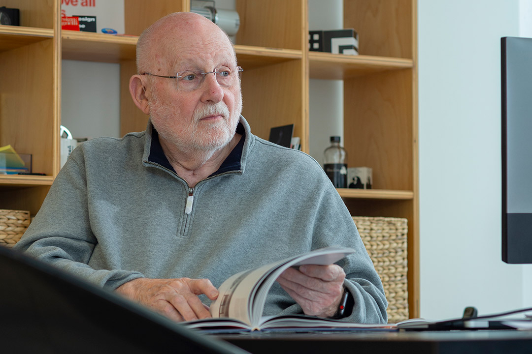 retiring professor looking through magazine on desk.