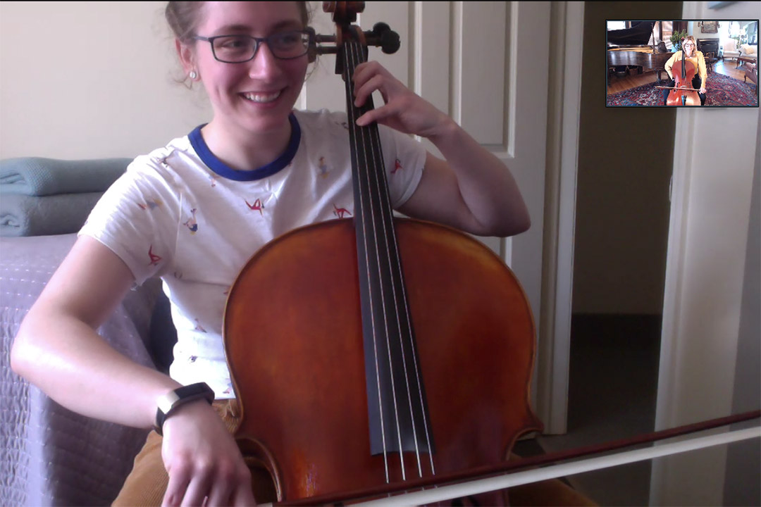 student playing the cello on video conference call with instructor also playing the cello.