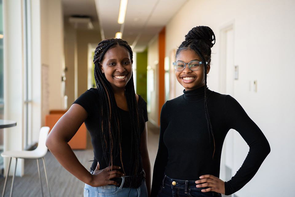 two students standing side-by-side.