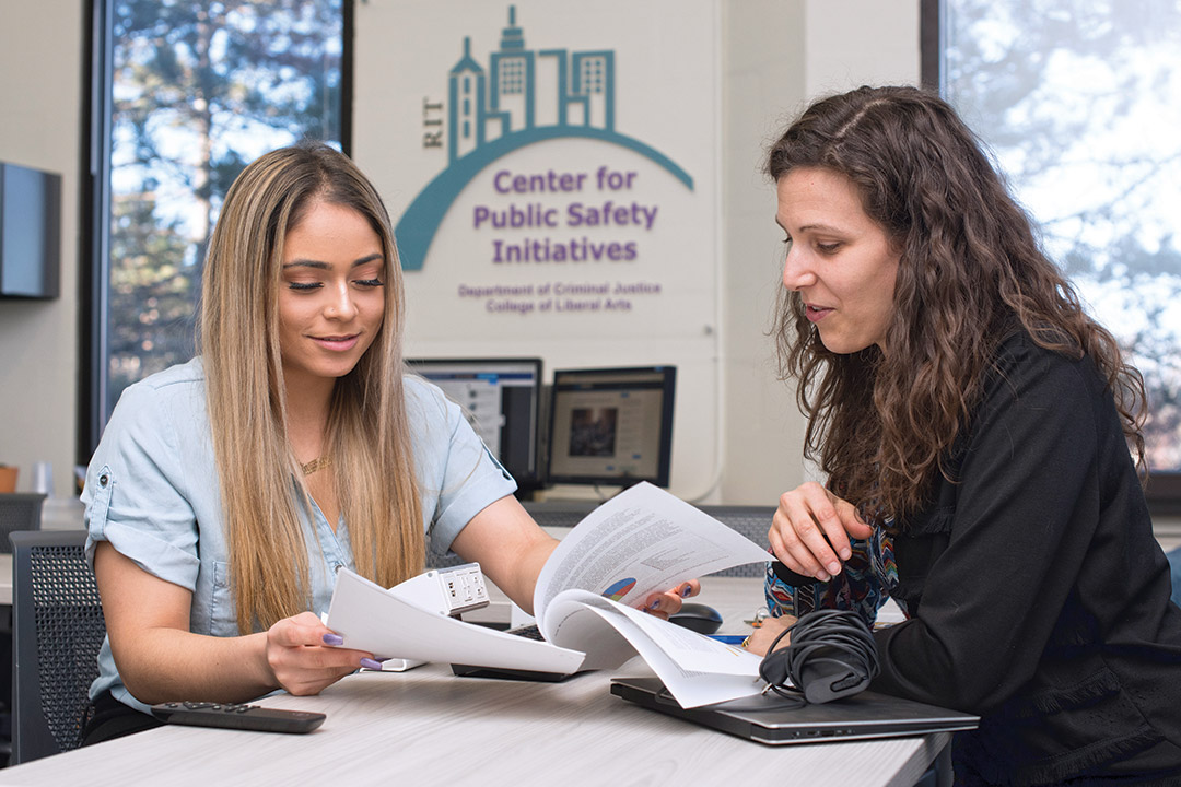 two women looking at report printout.