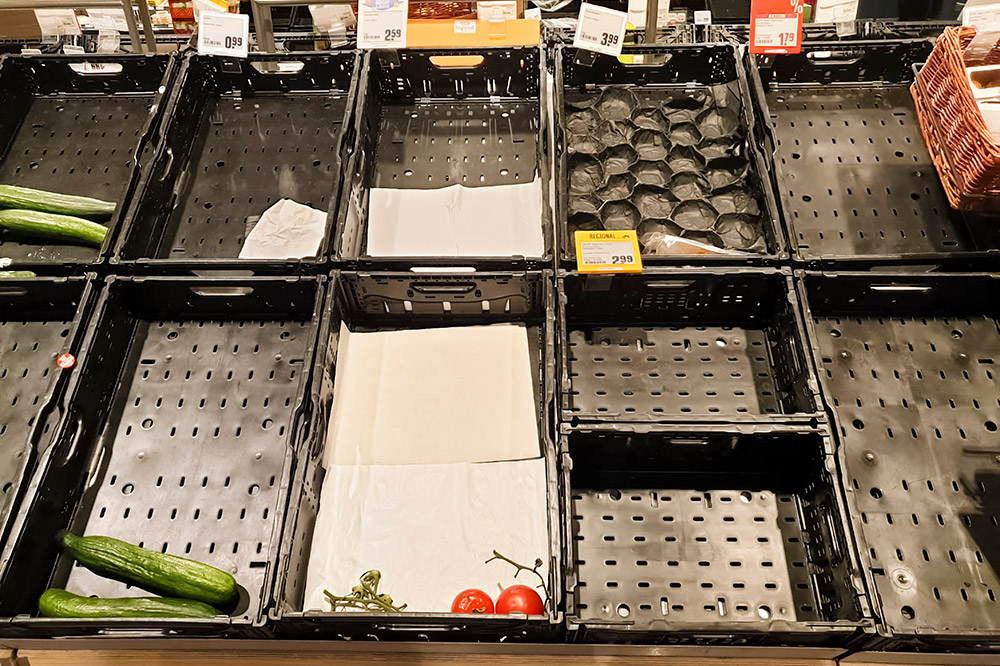 empty and near-empty bins of produce in a grocery store.