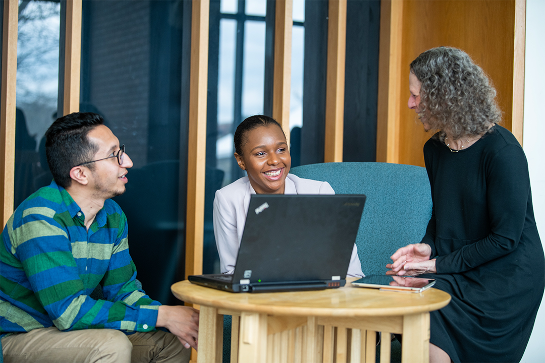 Students gathered talking to member of Student Services