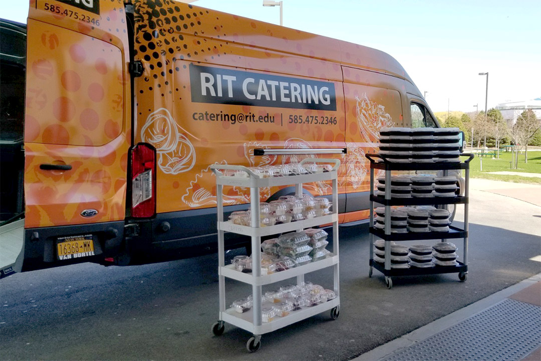 catering van with two racks of boxed meals.