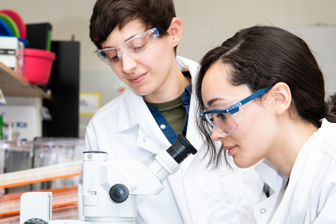 student looking into a microscope