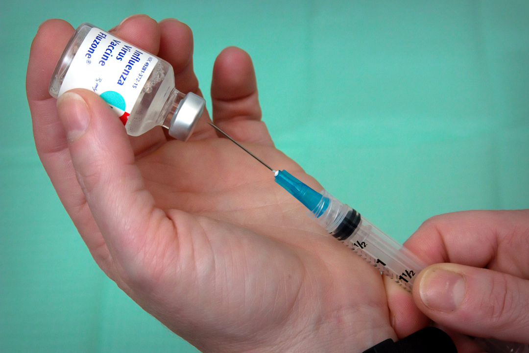 nurse extracting a dose of influenza vaccine