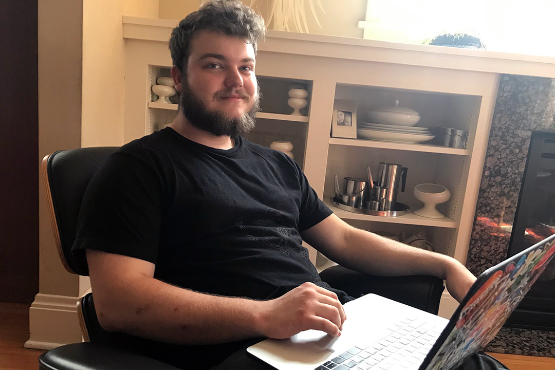 student sitting in a chair with a laptop.