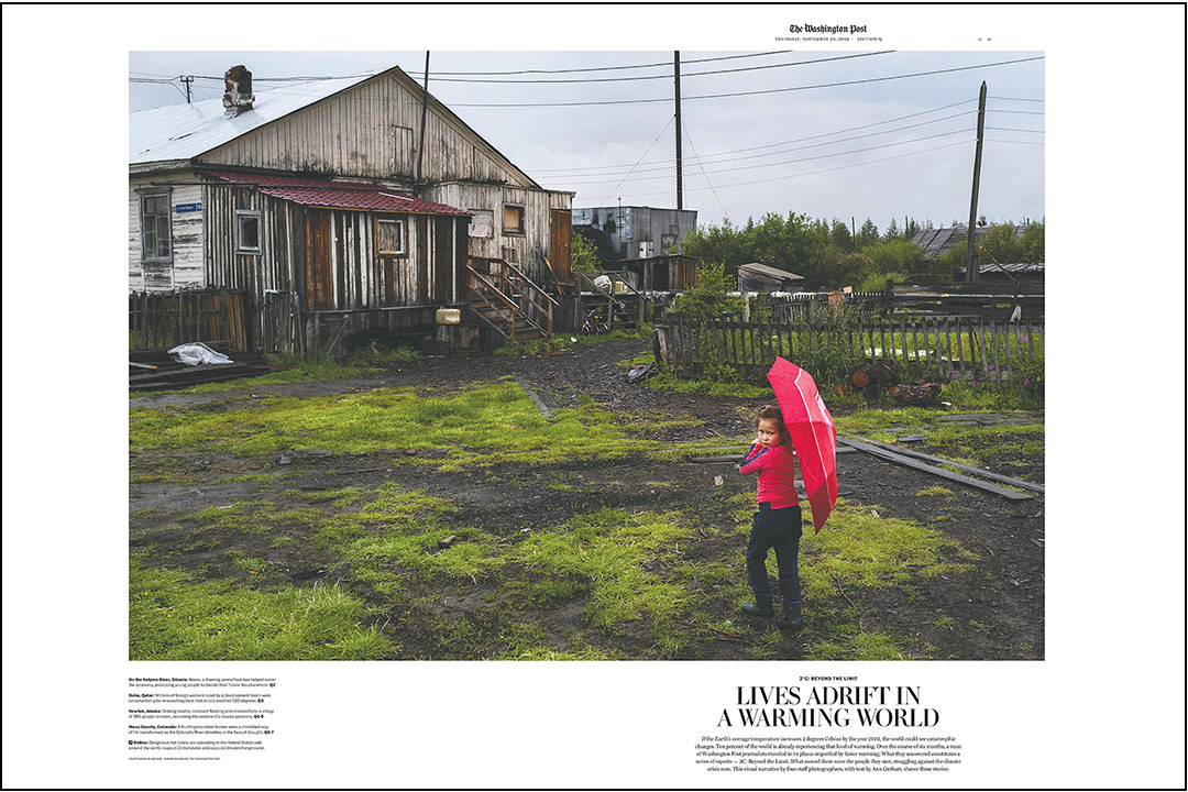 A young girl holding umbrella walks toward a decrepit-looking house.