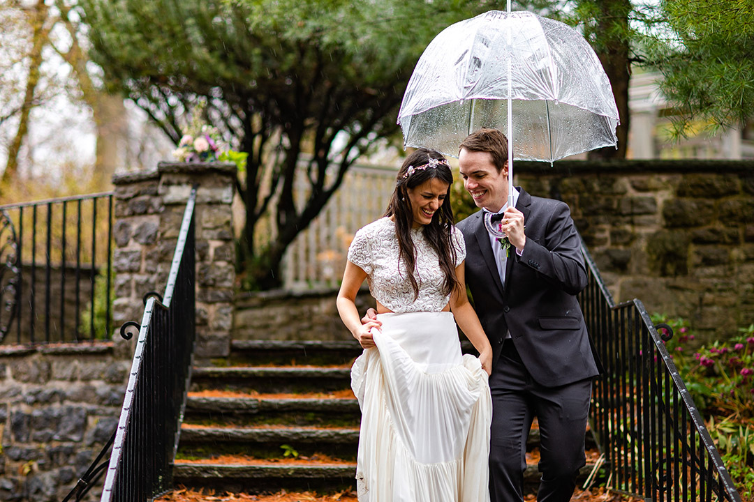 couple getting married poses under umbrella.