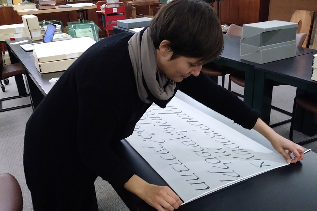 curator preparing banner with Hebrew text.