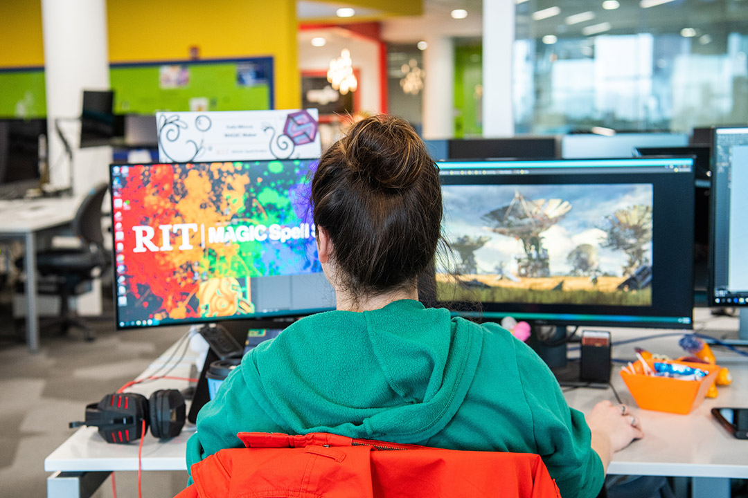 student looking at two side-by-side computer screens.