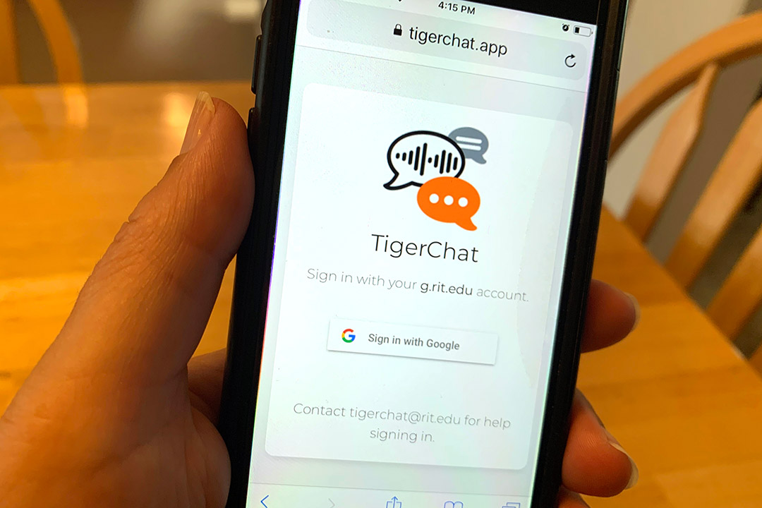 hand holding a smartphone showing the TigerChat app.