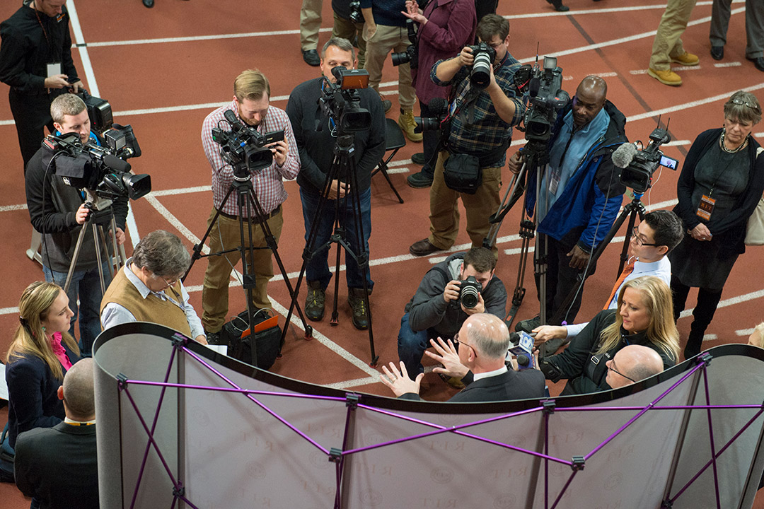 overhead view of news camera and reporters interviewing RIT President Munson.