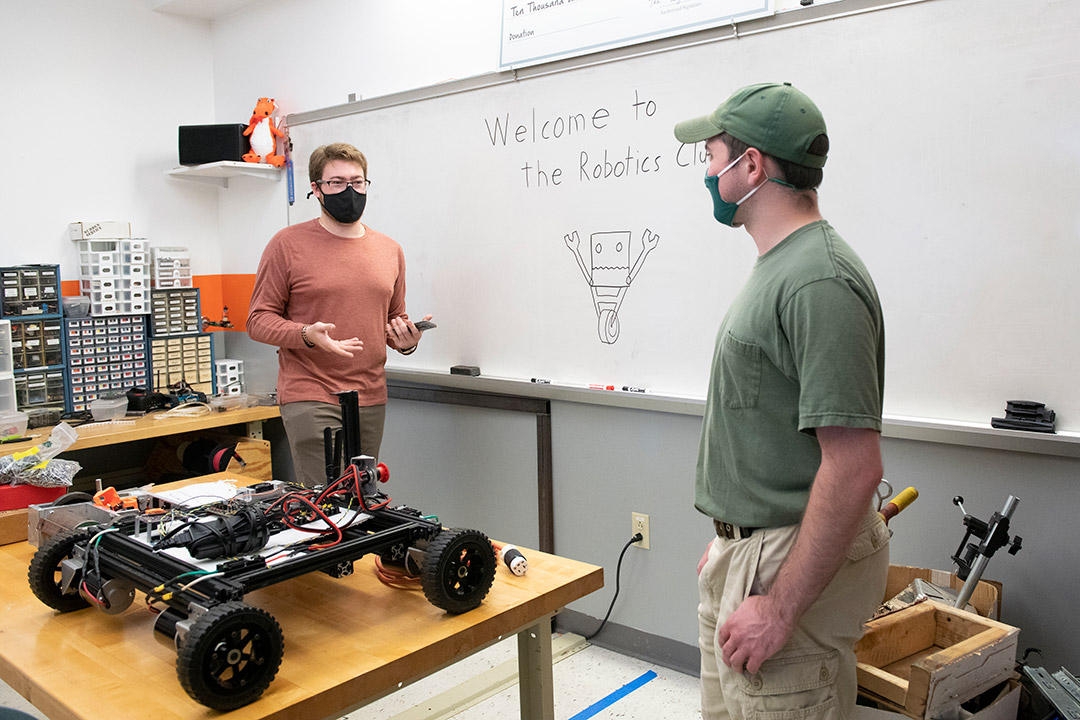 two students working in a robotics lab.