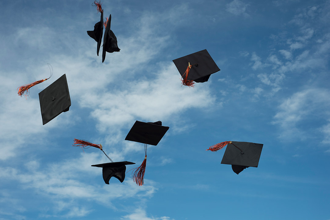 graduation caps in the air.