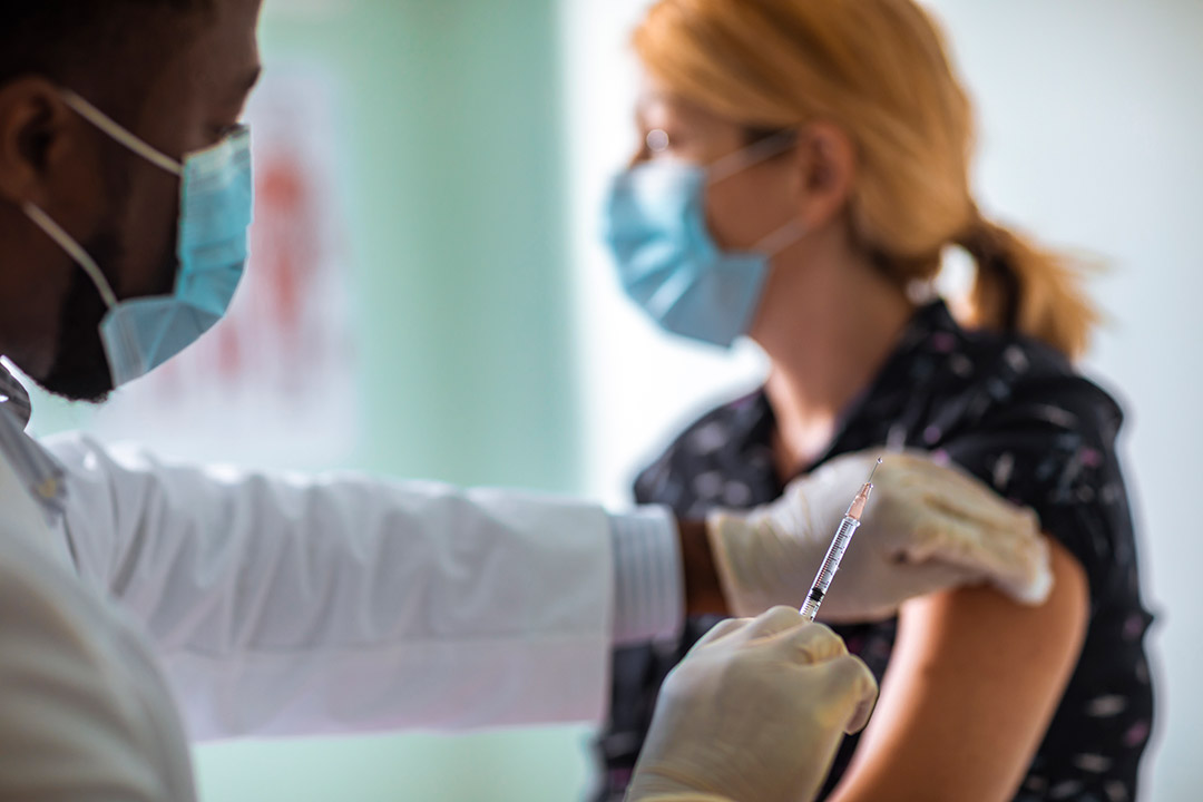 doctor getting ready to give patient a flu shot.