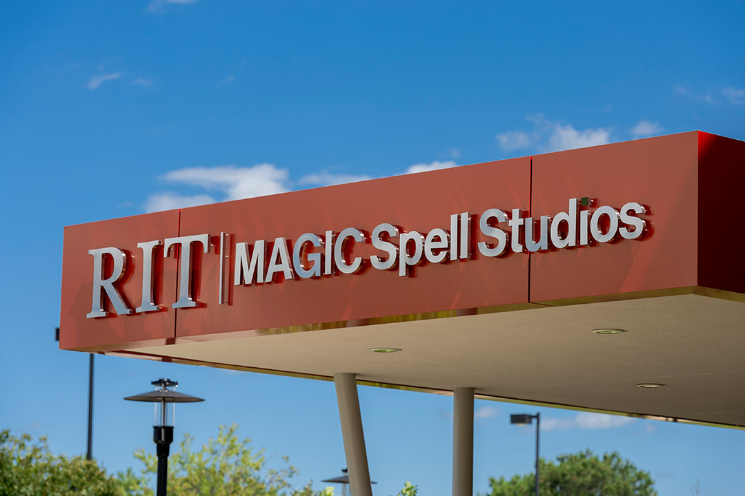 sign on building overhang that reads RIT MAGIC Spell Studios.