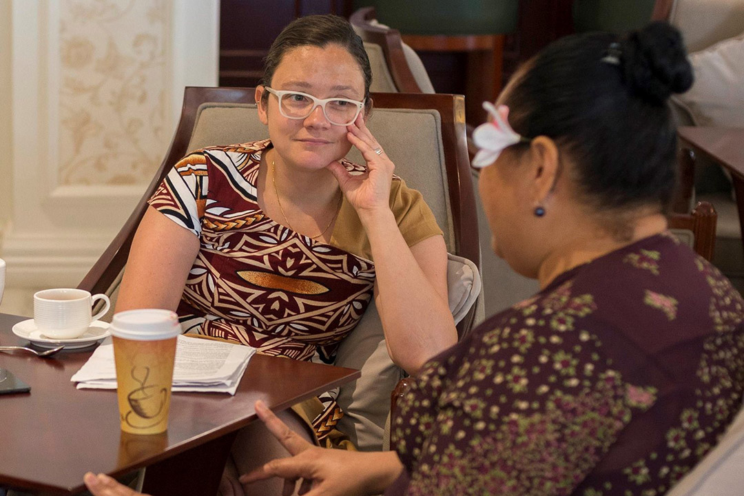 two women talking at cafe table.