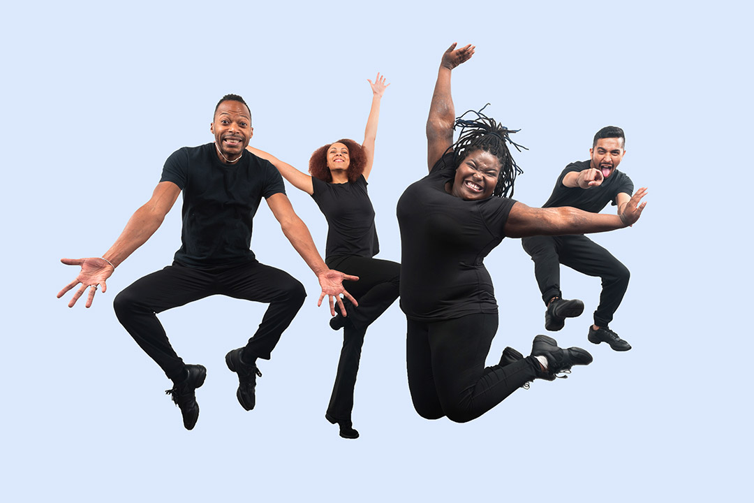 theater troupe wearing all black and jumping in the air.