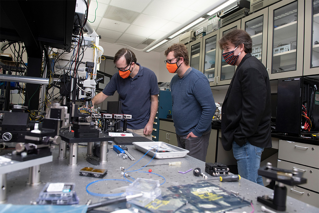 researchers in masks working in a lab.