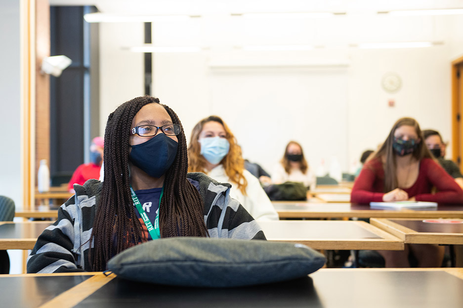 students wearing masks sitting at tables.